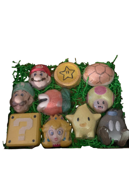 A variety of colorful bath bombs with Super Mario characters inside, arranged neatly in an open gift box.